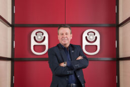 Portrait of CEO Jerry Fowden, Primo Water CEO from 2009-2019 with his arms crossed in front of vibrant red door at company headquarter’s in Tampa, Florida.