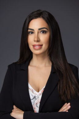 Professional headshot of female executive in studio setting with dark gray background on site in Tampa, Florida.