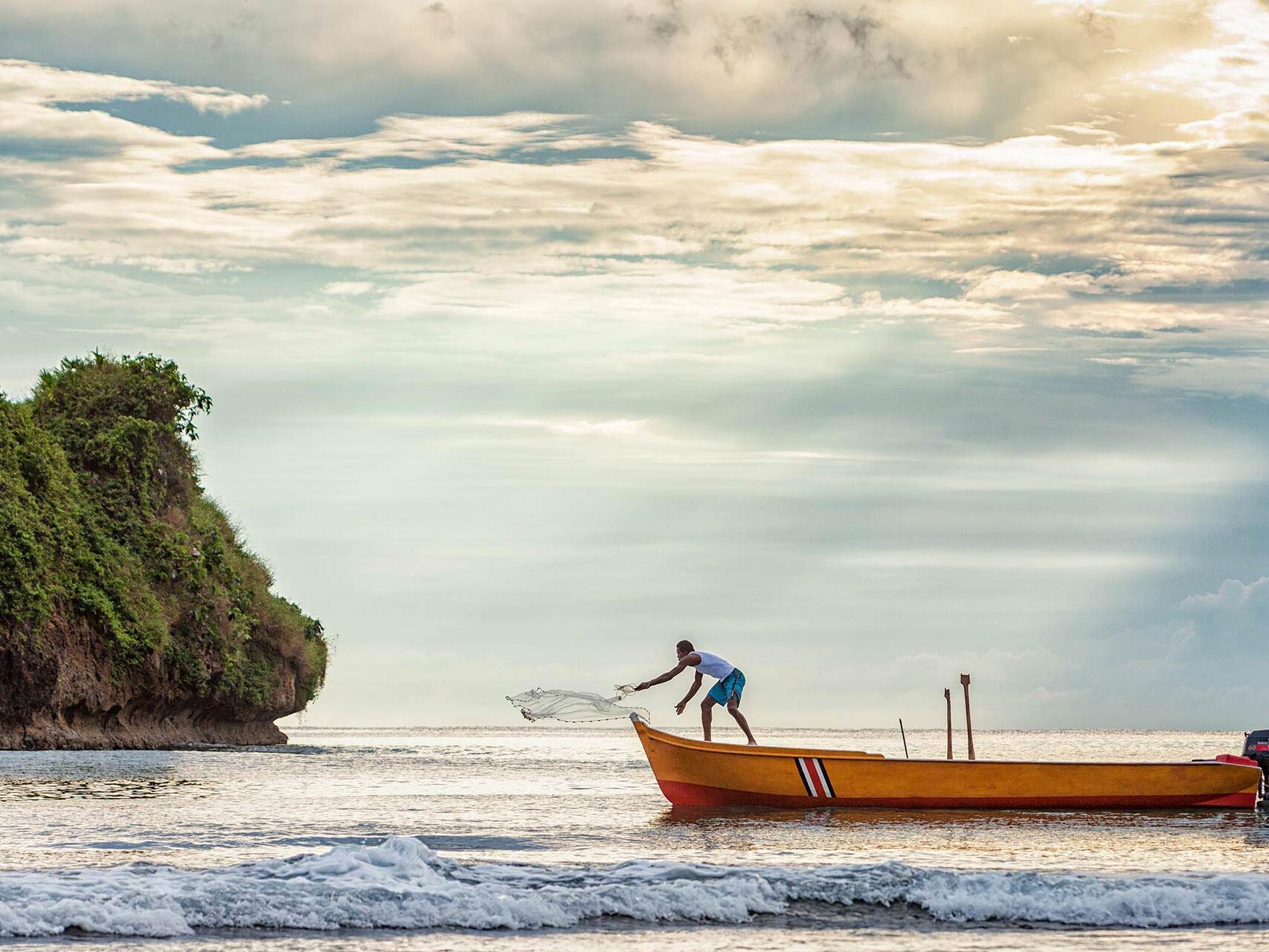 Lone fisherman casts net at sunrise in Puerto Viejo, Costa Rica by Tampa photographer Carver Mostardi.