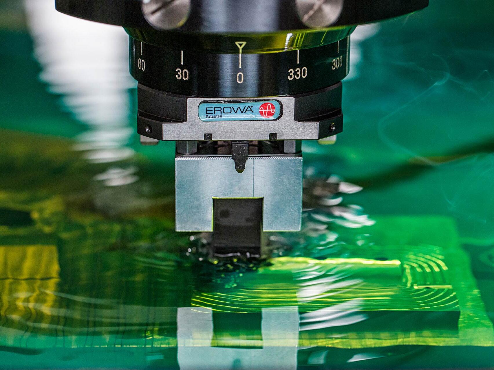 Electrical discharge machine (EDM), Makino sinker CNC, milling parts in green dielectric fluid - commercial industrial photography by Tampa based Carver Mostardi Photography.