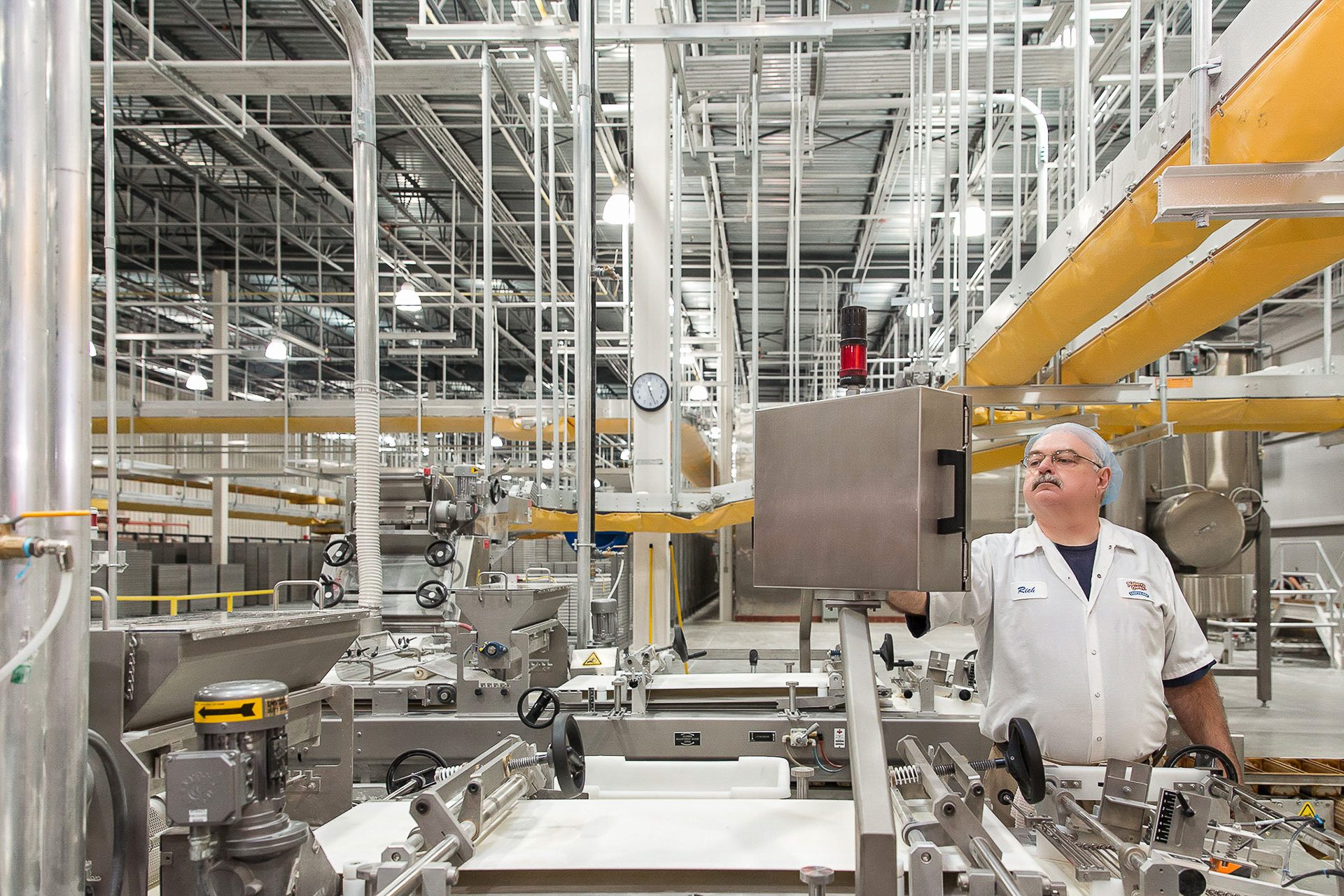 Industrial photography highlighting skilled personnel working alongside automated bakery machinery.