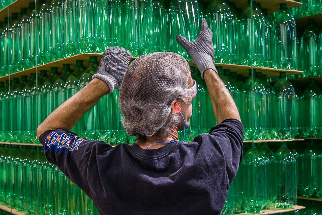 Industrial photo of worker managing production line in packaging facility.