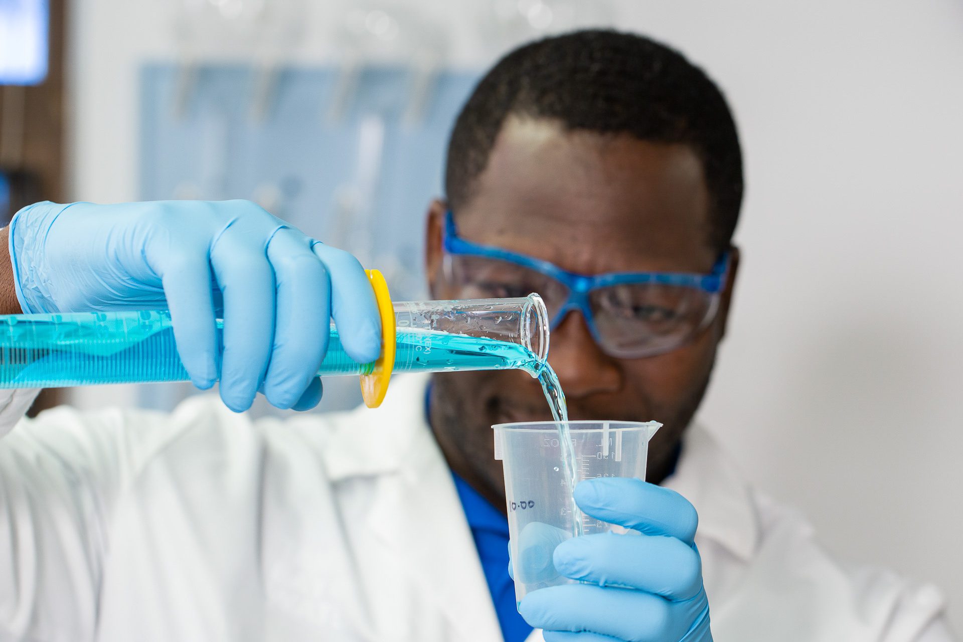 Industrial photographer capturing a scientist pouring liquid in a modern Orlando laboratory.