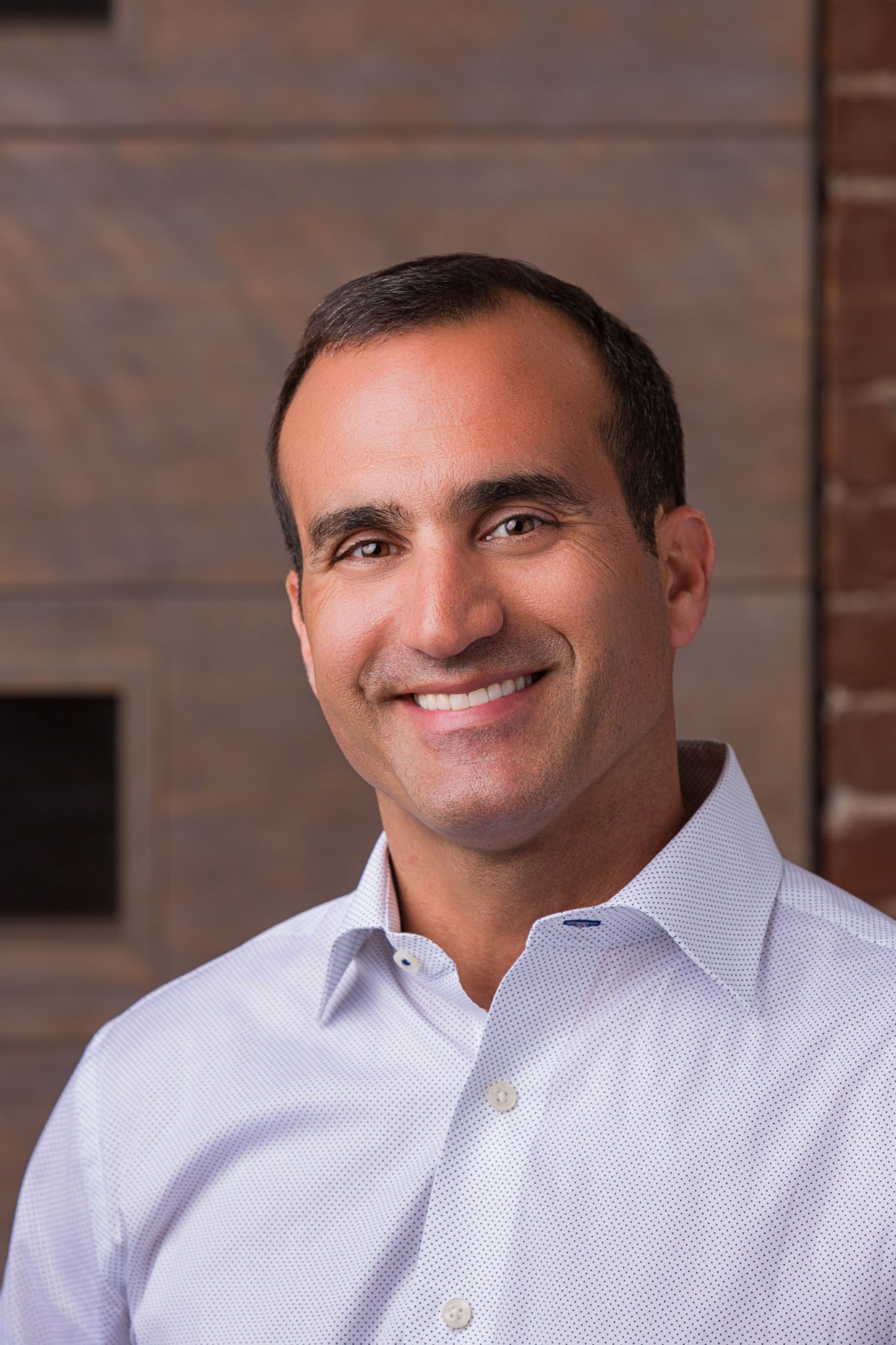 Tampa corporate photographer capturing professional business headshot in office with warm lighting and neutral tones.
