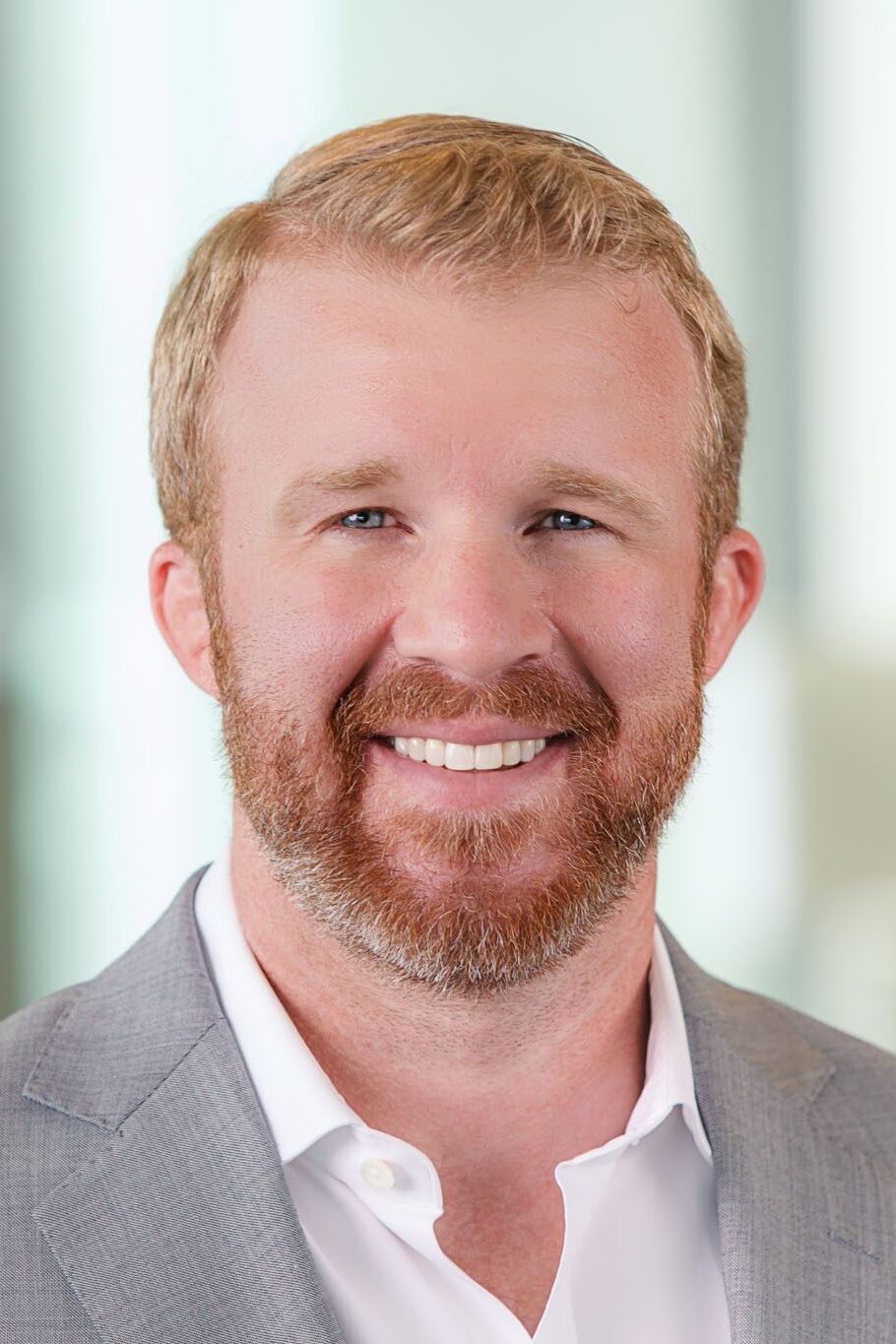 Tampa corporate photographer capturing professional business headshot of executive in bright modern office environment.