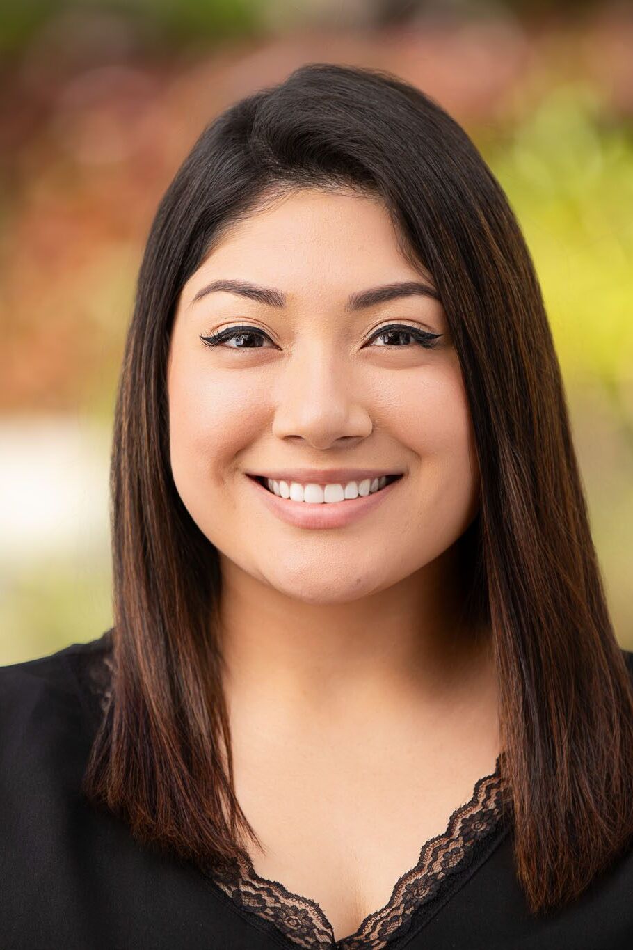 Tampa corporate photographer capturing outdoor professional headshot with natural light and blurred greenery background.