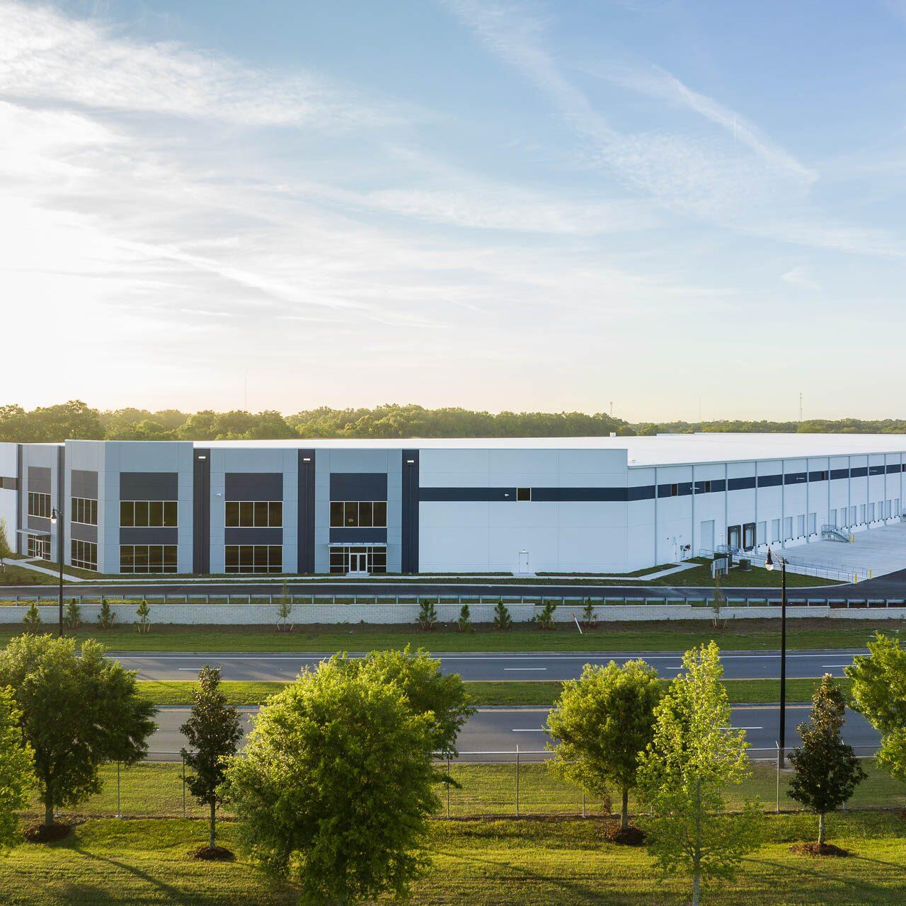 Aerial drone photograph of a large fulfillment center in Tampa, Florida showing modern architecture, loading docks, and landscaped surroundings.