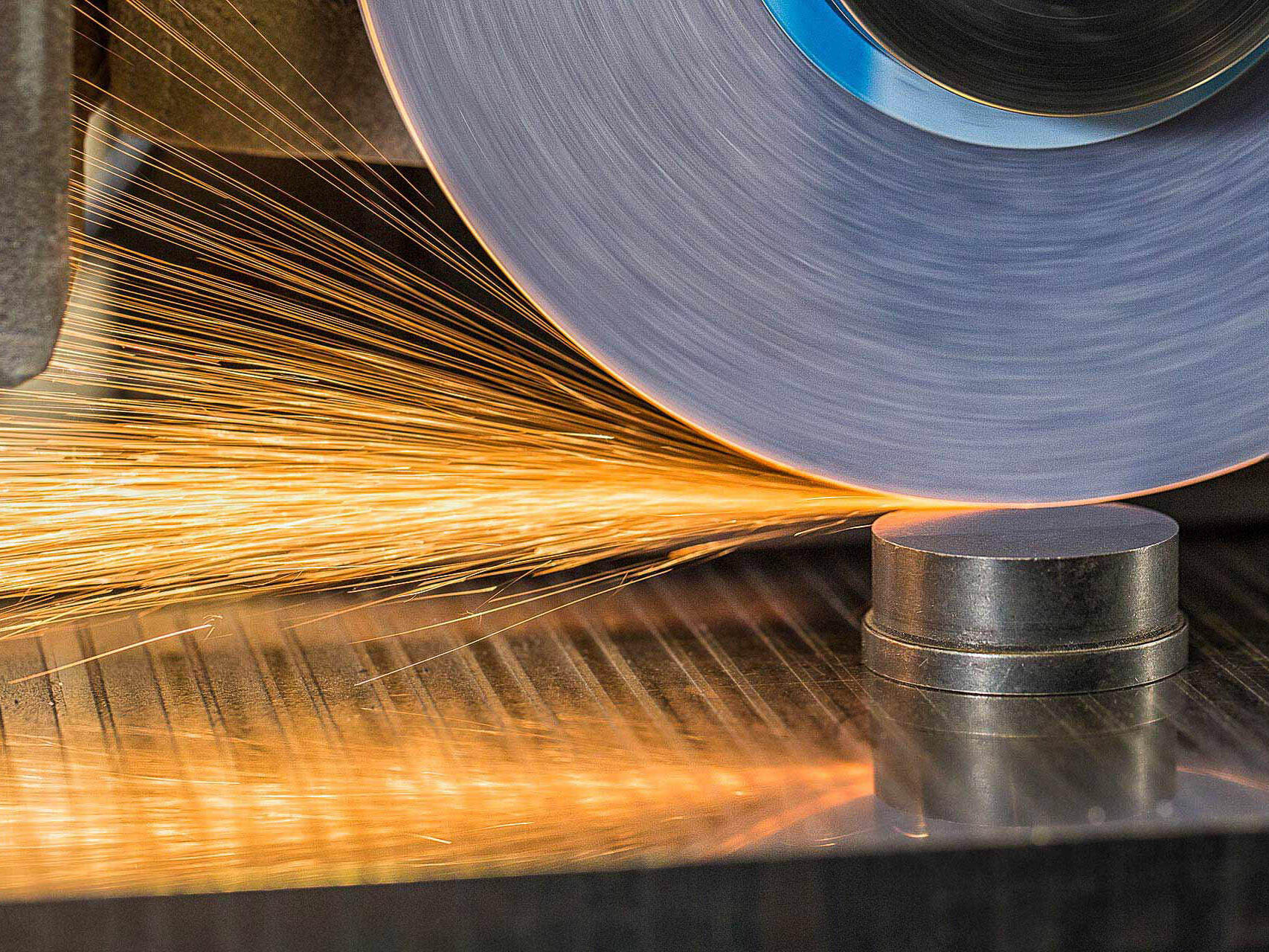 Sparks flying from industrial sanding machine - Tampa industrial photographer Carver Mostardi.