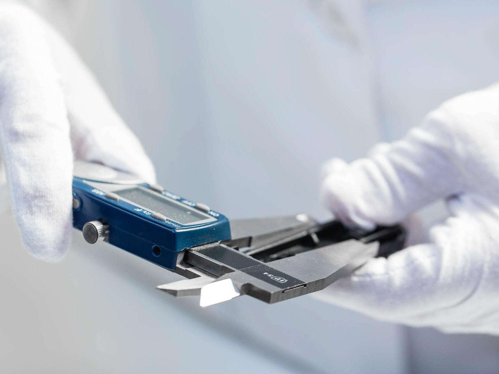 Lab technician measuring parts with caliper - Tampa commercial photographer Carver Mostardi.