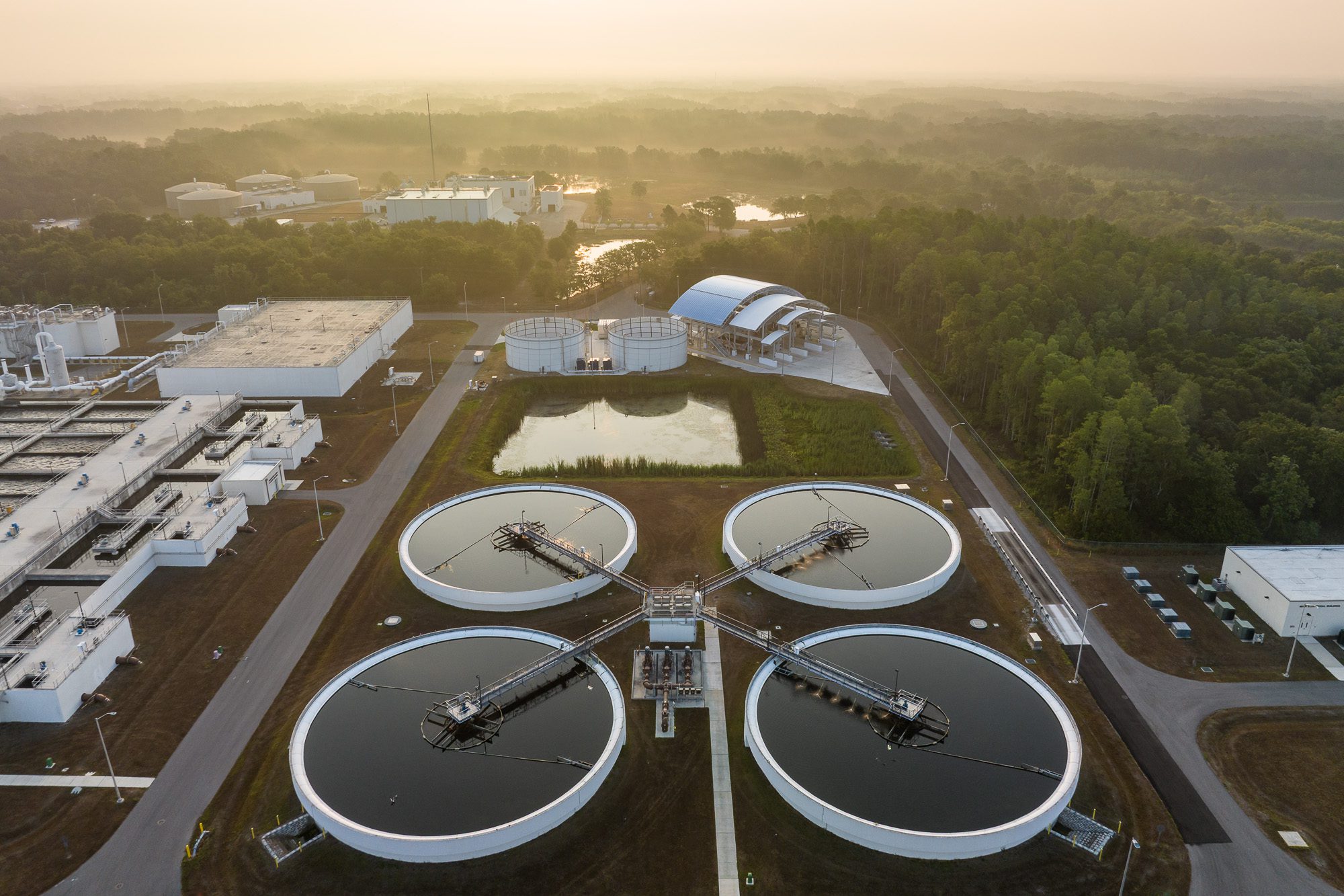 Aerial view of water treatment facility with clarifier basins and process layout at sunrise in Florida