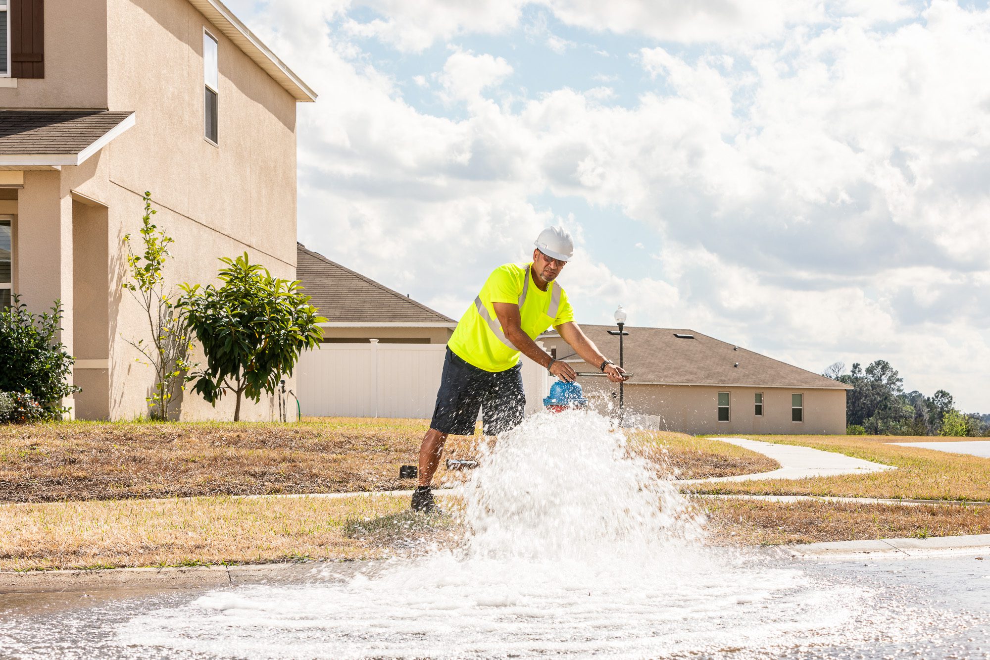 Field technician flushing water line in residential utility maintenance operation - infrastructure field work photography
